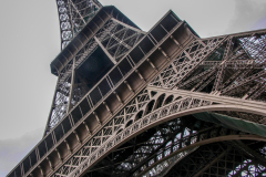 The Eiffel Tower on a rainy, gray spring day in Paris, France, blending into the overcast skyline