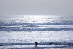 Man swimming in the Pacific Ocean at Stinson Beach, Marin County, California — winter day on the Northern California coast