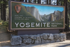 Spring landscape of Yosemite Valley with waterfalls, trees, and granite cliffs in California. Entrance sign to Yosemite National Park