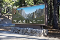 Spring landscape of Yosemite Valley with waterfalls, trees, and granite cliffs in California. Entrance sign to Yosemite National Park